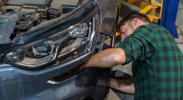Mecânico que alinha o amortecedor do carro na oficina