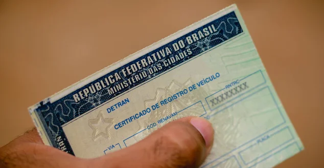 Homem possui Certificado de Registro de Veículo (CRV). É o documento emitido anualmente para indicar que o carro está apto a circular pelas ruas do Brasil.