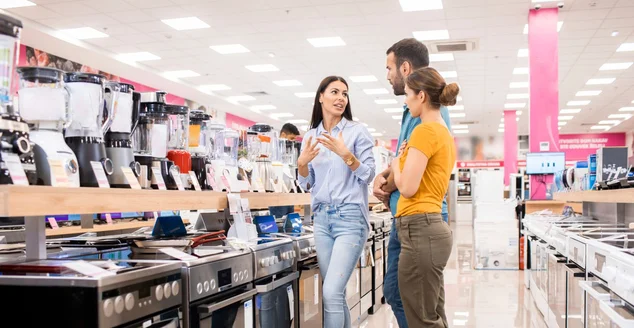 Vendedora ajuda clientes com espremedor elétrico