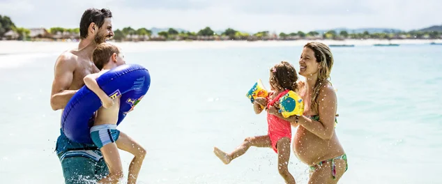 Jovem família brincalhão se divertindo no mar.