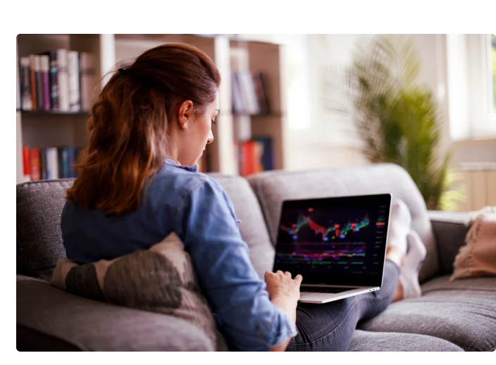 mulher mexendo no computador verificando gráficos da bolsa de valores