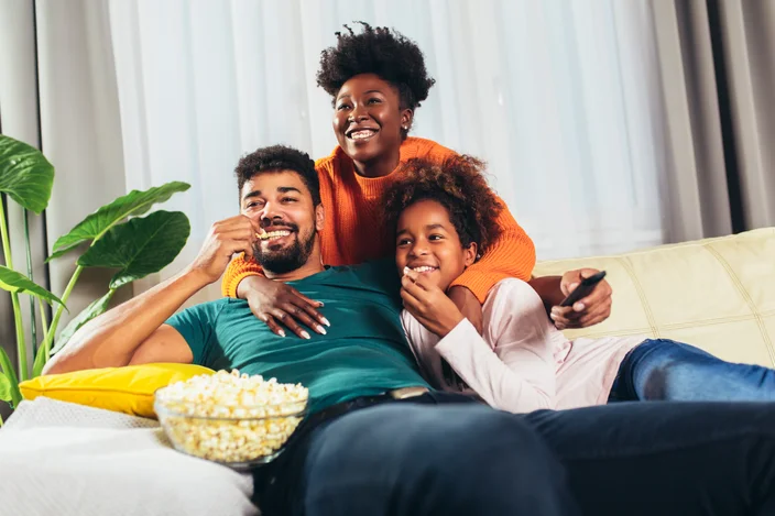 Família afro-americana relaxada assistindo TV juntos.