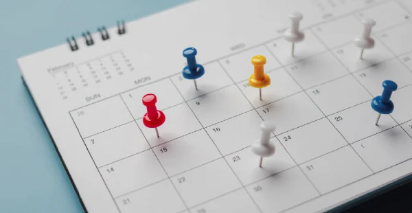 Pinos vermelhos bordados em um evento de calendário Calendário, relógio para definir cronograma organizar programação, planejamento para reunião de negócios ou conceito de planejamento de viagem.