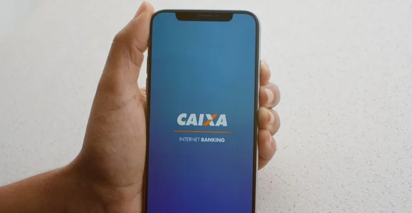 Close de um celular mostrando o aplicativo de internet banking da Caixa Econômica Federal, controle financeiro prático.