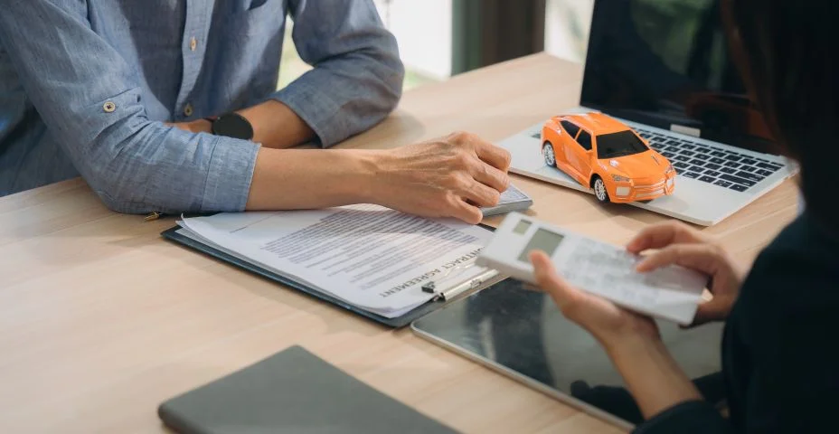 Consulta de empréstimo de carro: close-up de um consultor financeiro e cliente revisando documentos de empréstimo de carro, o que significa confiança e planejamento financeiro.