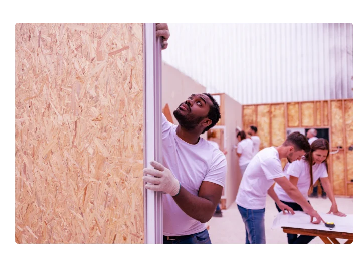 Voluntário instalando uma janela enquanto construía uma casa