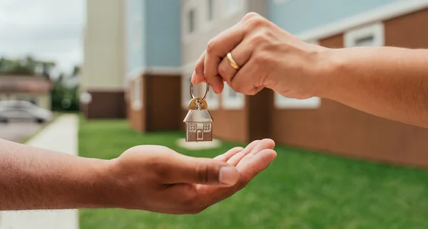 Detalhe das mãos do agente imobiliário entregando as chaves