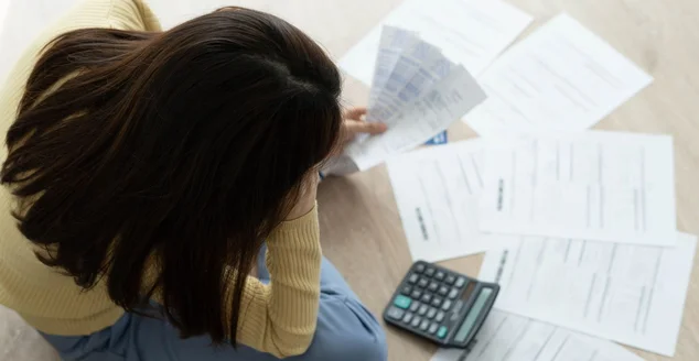 As mulheres se estressam com muitas dívidas de cartão de crédito e contas no chão. A dona de casa tem dificuldade para calcular as despesas mensais e o orçamento não é suficiente para quitar a dívida