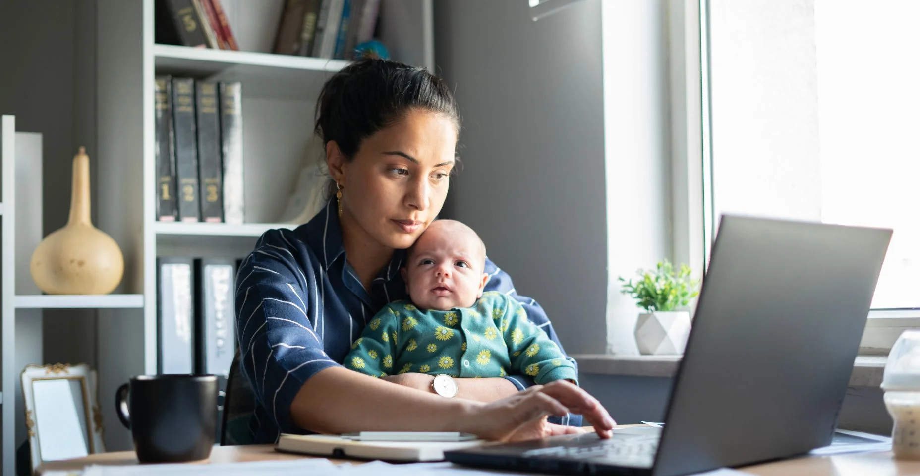Mulher nova que trabalha com seu bebê no home office