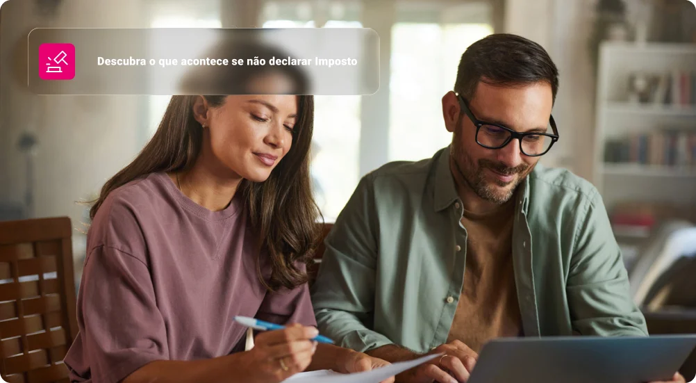 Casal sorridente trabalhando em relatórios e laptop em casa.