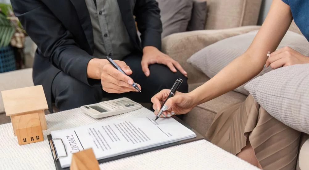Finalização de negócios imobiliários. Cliente assinando contrato para compra de novo imóvel.