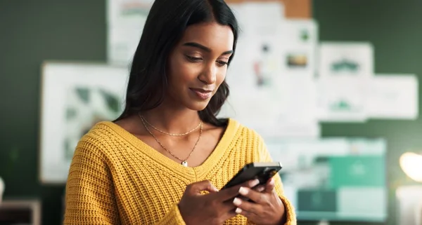 Mulher sorrindo para o celular na sala de estudo para grupo de elearning e anúncio.