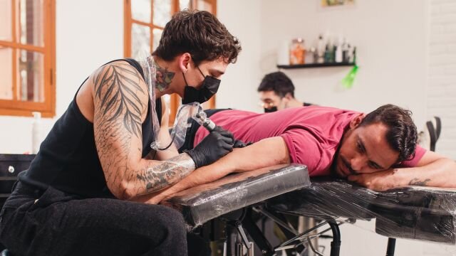 homem sendo tatuado