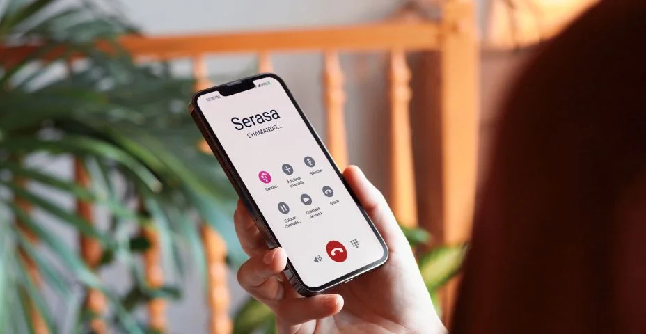 Maquete de mulher em casa segurando smartphone com tela personalizável