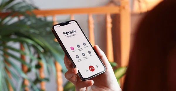 Maquete de mulher em casa segurando smartphone com tela personalizável
