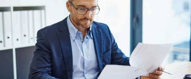 Homem verificando documentos para ilustrar artigo sobre o que é holerite