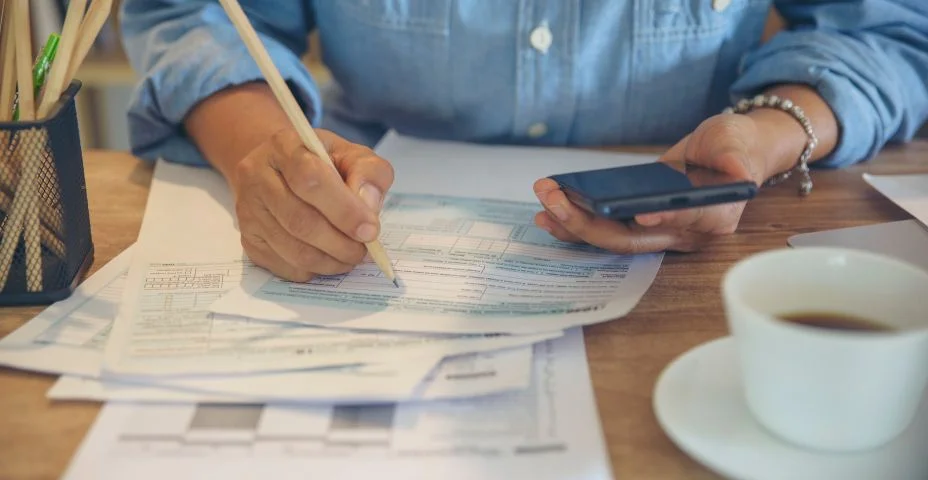 Conceito de planejamento orçamentário, o Contador está calculando o imposto anual da empresa. Calendário 2022 e formulários de imposto de renda pessoal para aqueles que têm renda sob a lei dos EUA colocados na mesa de escritório.