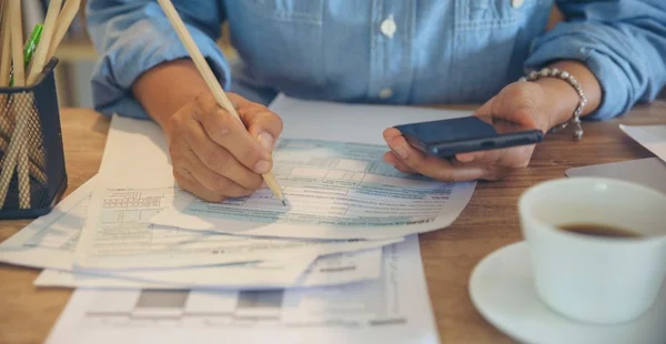 Conceito de planejamento orçamentário, o Contador está calculando o imposto anual da empresa. Calendário 2022 e formulários de imposto de renda pessoal para aqueles que têm renda sob a lei dos EUA colocados na mesa de escritório.