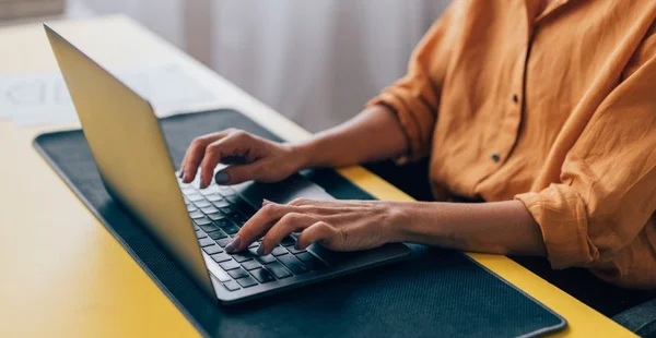 Mulher profissional que trabalha no laptop no espaço de trabalho moderno