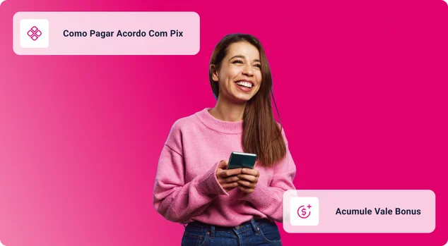 Mulher jovem feliz no suéter cor-de-rosa olhando para longe com um grande sorriso enquanto segura o celular nas mãos