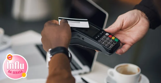 Close-up de um homem negro pagando uma conta com cartão de crédito