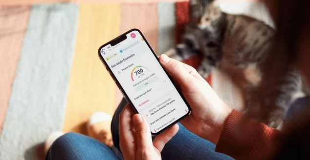 Celular com login da Serasa ao lado de um notebook para ilustrar artigo sobre score