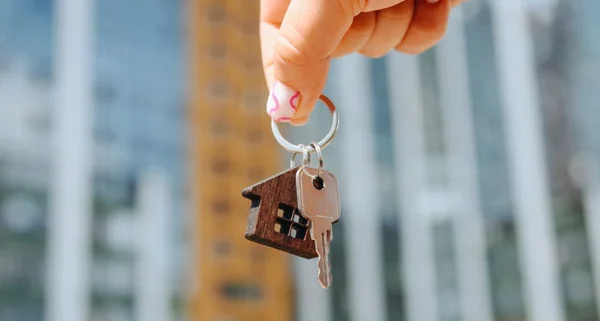 Mão da mulher com chave nova do apartamento