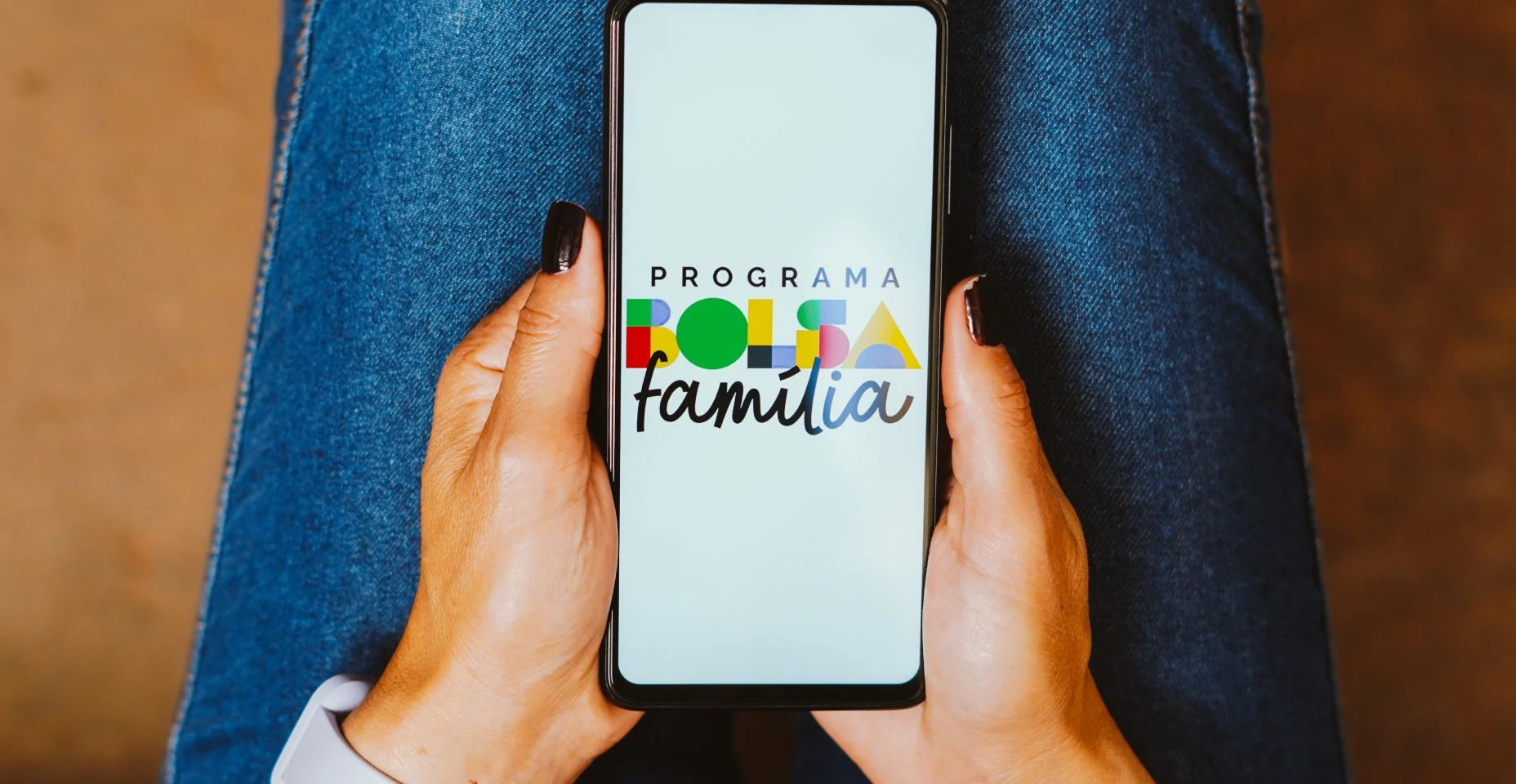 Nesta ilustração fotográfica, o logotipo do Bolsa Família é exibido em um smartphone
