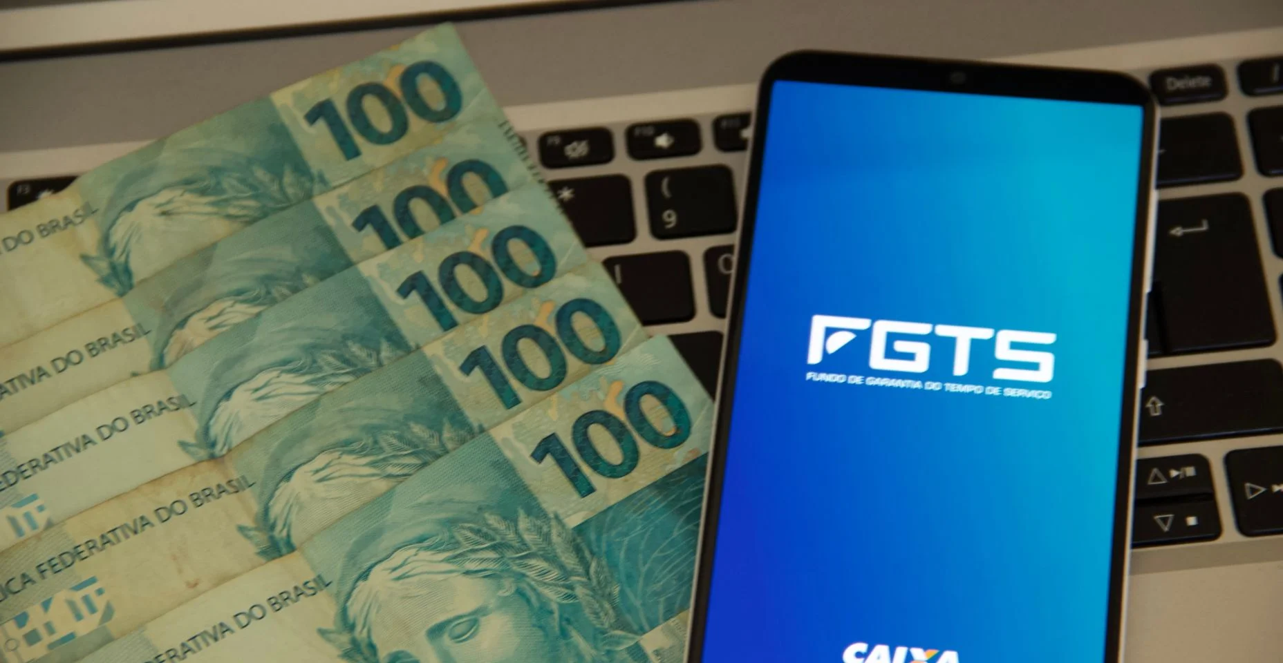 app do FGTS aberto perto de varias notas de 100R$