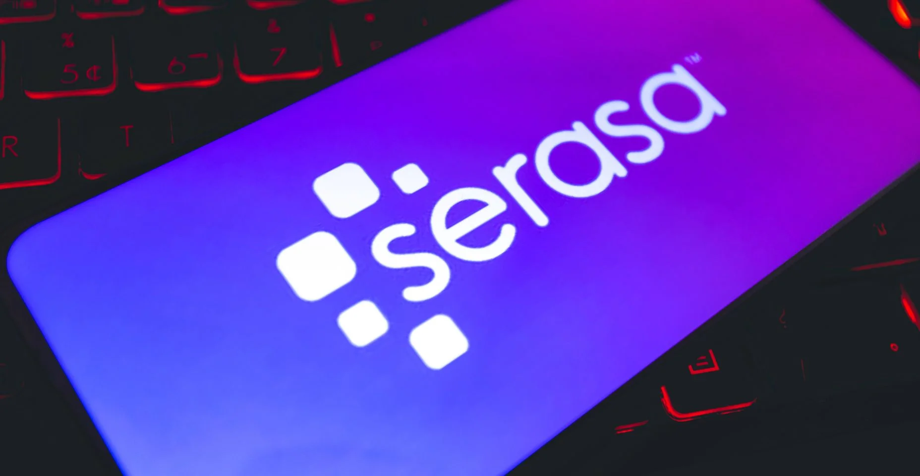 Serasa. Um telefone celular com a logo da empresa brasileira Serasa sobre um teclado de notebook.