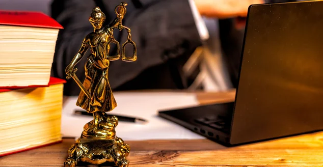 Escritório de uma advogada com estátua de Lady Justice, deusa Justitia, sobre a mesa -