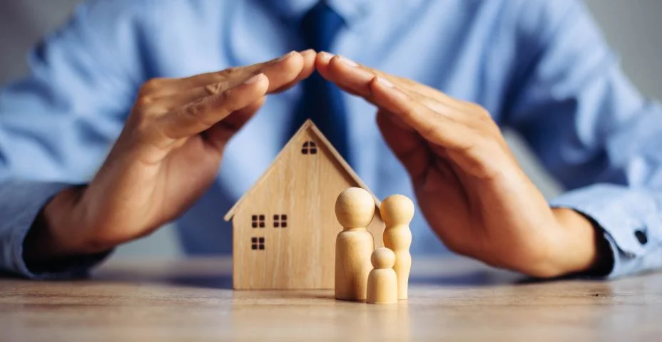 Casa de seguros e conceito de saúde familiar. O corretor de seguros apresenta o modelo de proteção das mãos que simboliza a cobertura.
