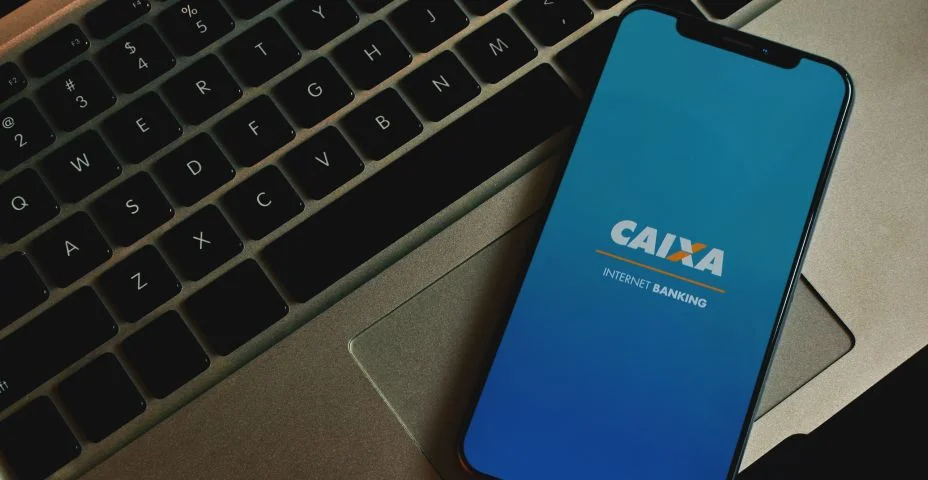 Close de um smartphone exibindo o aplicativo da Caixa Econômica Federal para internet banking, comodidade financeira na palma da sua mão.