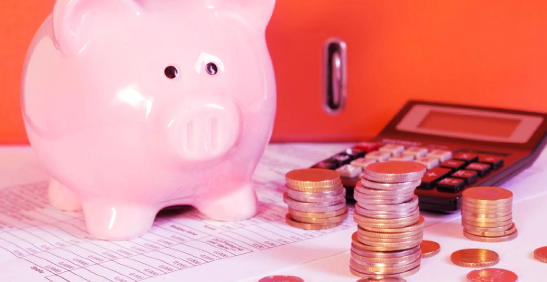 Porquinho de dinheiro ao lado de uma calculadora para ilustrar o artigo sobre 12 dicas para economizar dinheiro no seu dia a dia