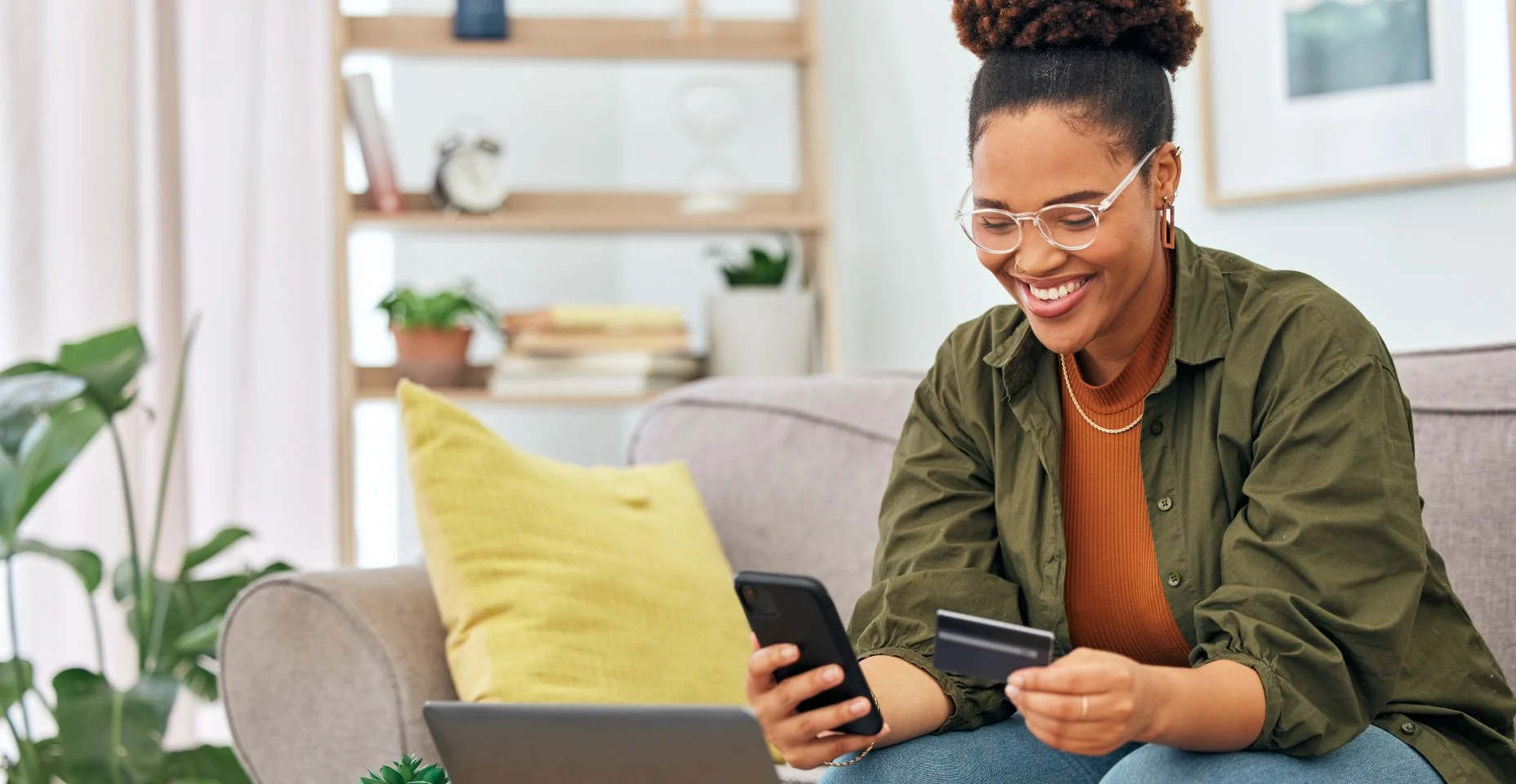 Mulher negra feliz, cartão de crédito e compras online no smartphone para pagamento digital, conta fintech ou finanças em casa.