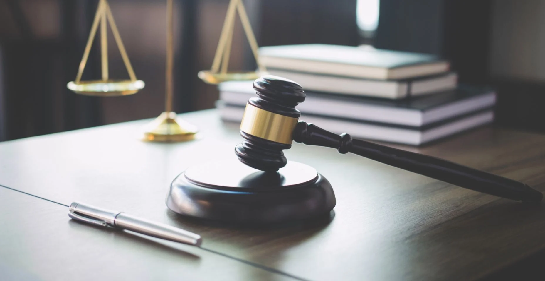 Escalas de Justiça e o martelo na mesa de madeira e advogado ou juiz trabalhando com acordo no conceito de direito, a justiça e o Tribunal