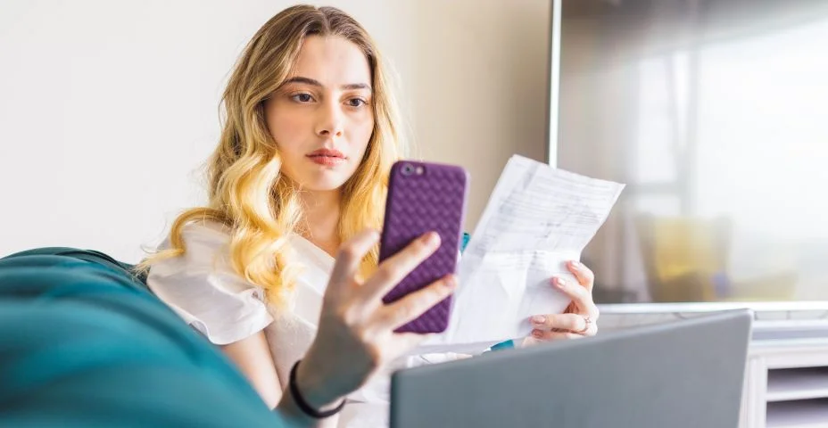 Mulher que está surpreso ao ver sua conta bancária ao pagar sua fatura