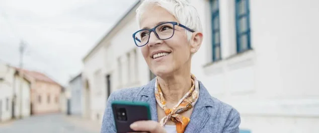 Senhora com celular na mão verificando tudo sobre o Empréstimo BPC