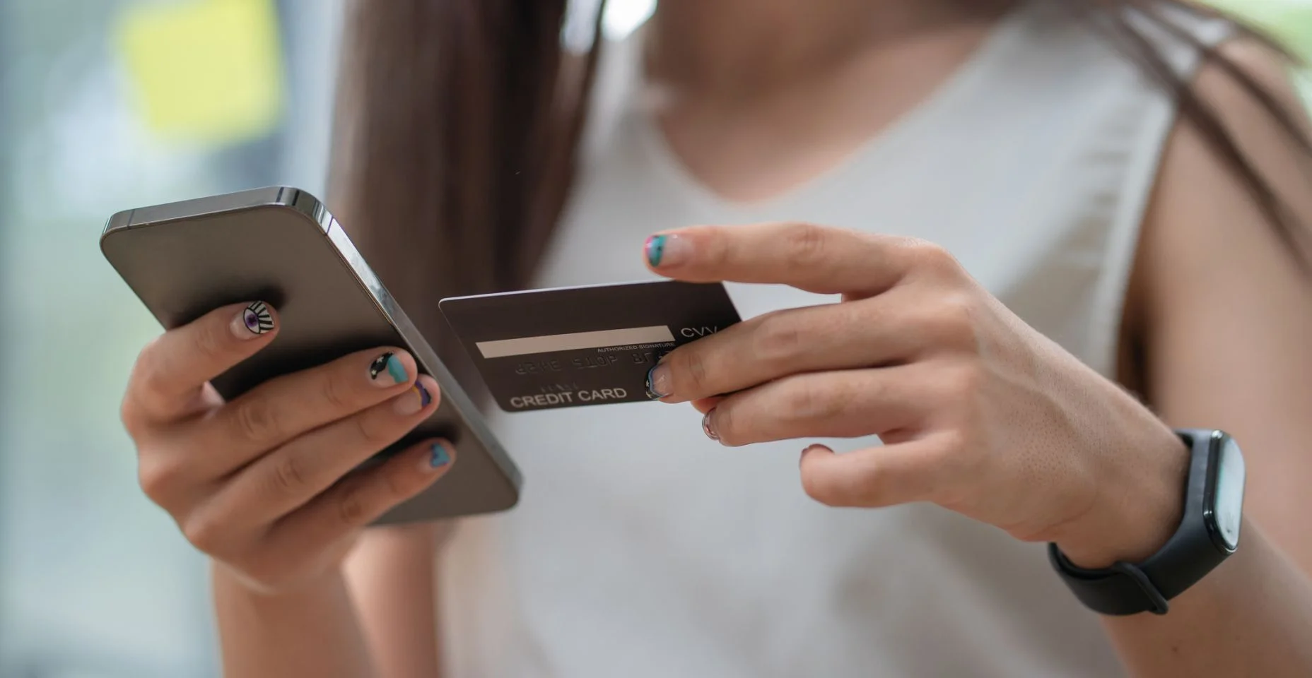 Mãos segurando cartão de crédito e usando o smartphone celular com compras pela manhã, online