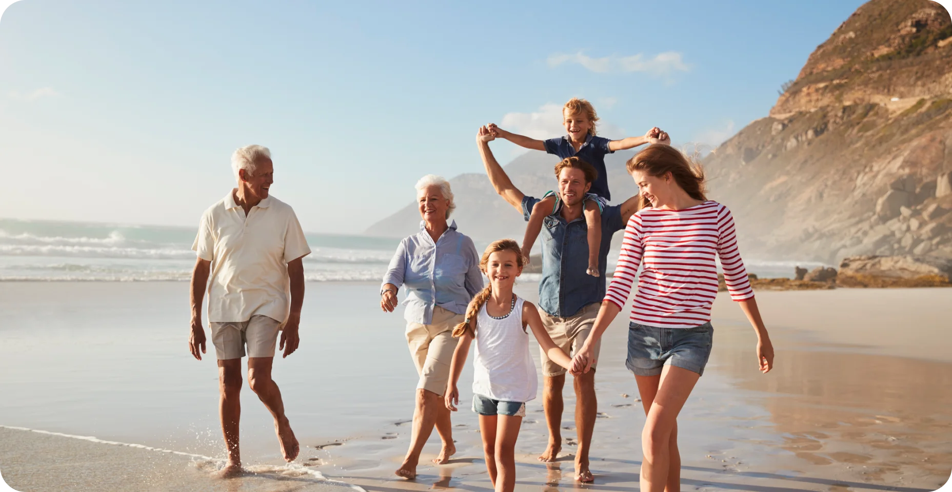 Família de geração multi de férias andando praia juntos