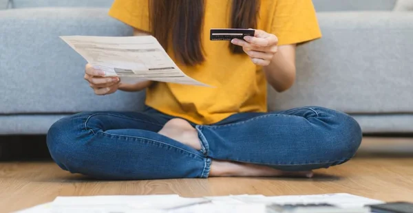 Conceito de empréstimo financeiro e dívida, Mulheres segurando cartão de crédito maquete e fatura durante o cálculo de despesas mensais.