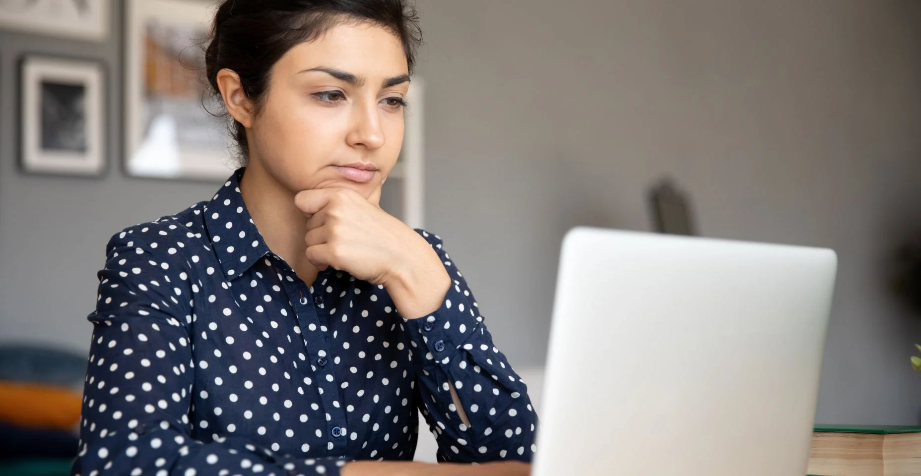 Uma jovem indiana atenciosa olhando para a tela do computador.