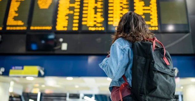 Mulher na estação verificando o horário de seu voô.