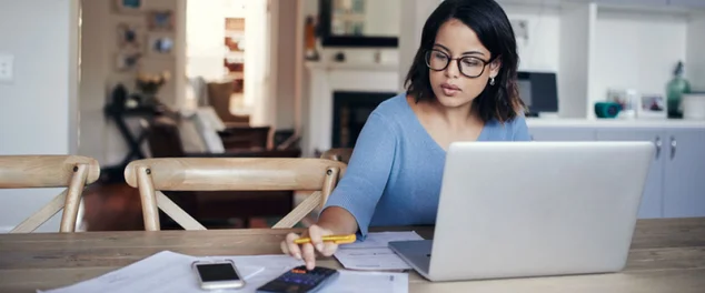 Mulher mexendo em seu notebook e em seu celular para ilustrar artigo sobre dissídio salarial e quem tem direito a ele