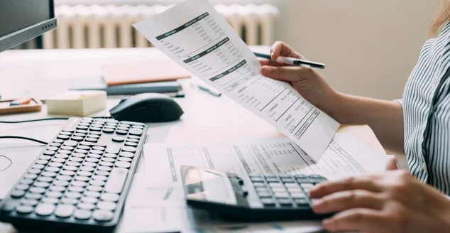 Contadora irreconhecível analisando os registros financeiros