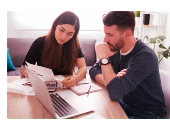 homem e mulher de frente ou notebook avaliando contas.