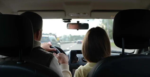 Vista traseira do homem dirigindo carro e batendo punho com a filha adolescente. Close up do pai com a menina no veículo durante a viagem.