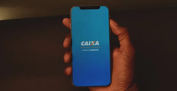 Detalhe do smartphone com o aplicativo internet banking da Caixa Econômica Federal, praticidade para suas transações.