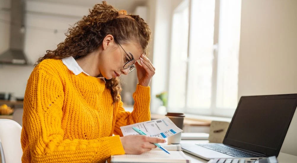 Mulher preocupada organizando as finanças doméstica