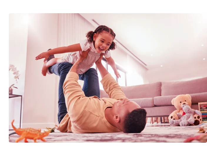 pai e menina brincando em uma casa com liberdade, se unindo e desfrutando de tempo de qualidade juntos. Felicidade, sorriso e criança a voar nos braços dos pais no chão num fim de semana em casa